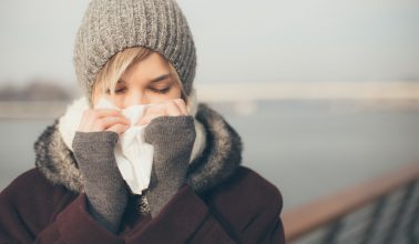 Young woman with a cold holding a tissue