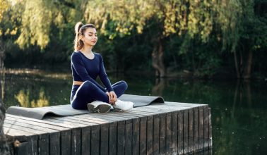 young-woman-on-a-yoga-mat-relaxing-outdoors