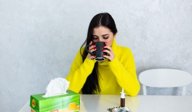pills-and-tea-young-woman-taking-pills-and-drinking-hot-tea-having-cold