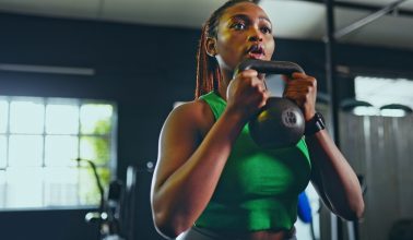 Exercise, kettlebell and black woman in gym, for fitness and workout for wellness, health and training. Healthy girl, African American female and athlete with equipment for practice, cardio or strong